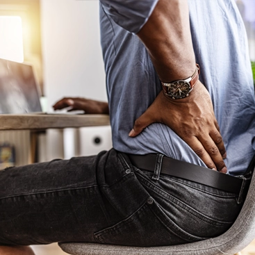 Chiropractic Middle Village NY Man Sitting With Back Pain